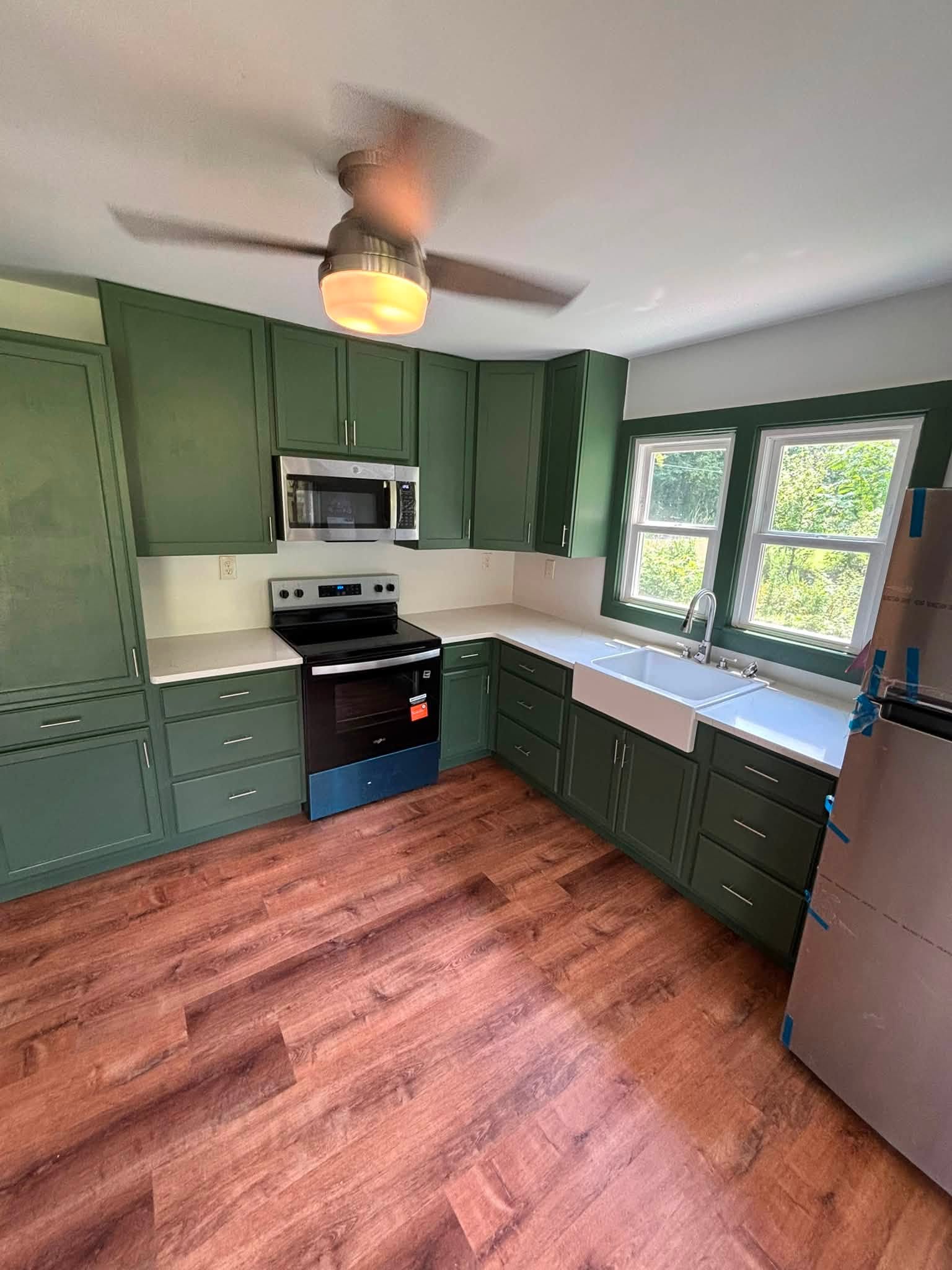 Finished kitchen remodeling by K&S Contracting LLC with green cabinets and farmhouse sink