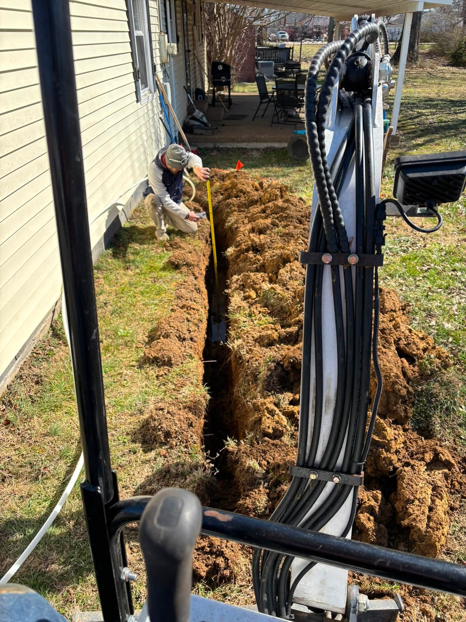 K&S Contracting measuring a drainage trench on a residential job site